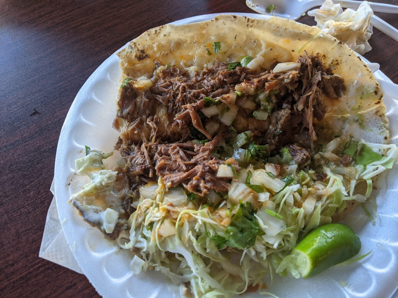 Carnitas taco with shredded pork, cabbage, and lime